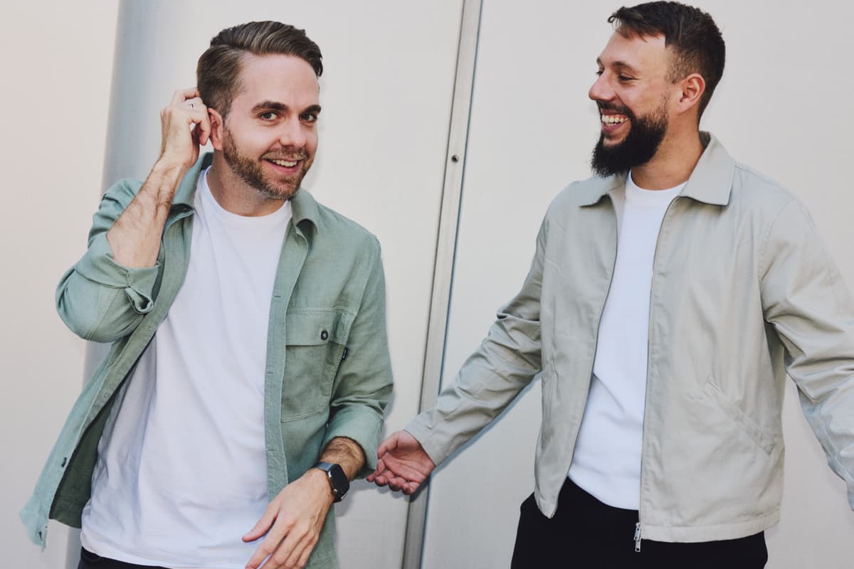 Daniel Wenz und Mirco Recksiek, die Gründer von Bitcoin2Go, lächelnd vor einer modernen Gebäudefassade